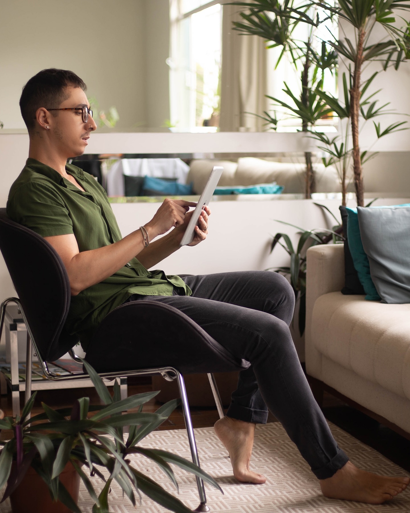 Layon em atendimento online pelo tablet, na sala clara com plantas